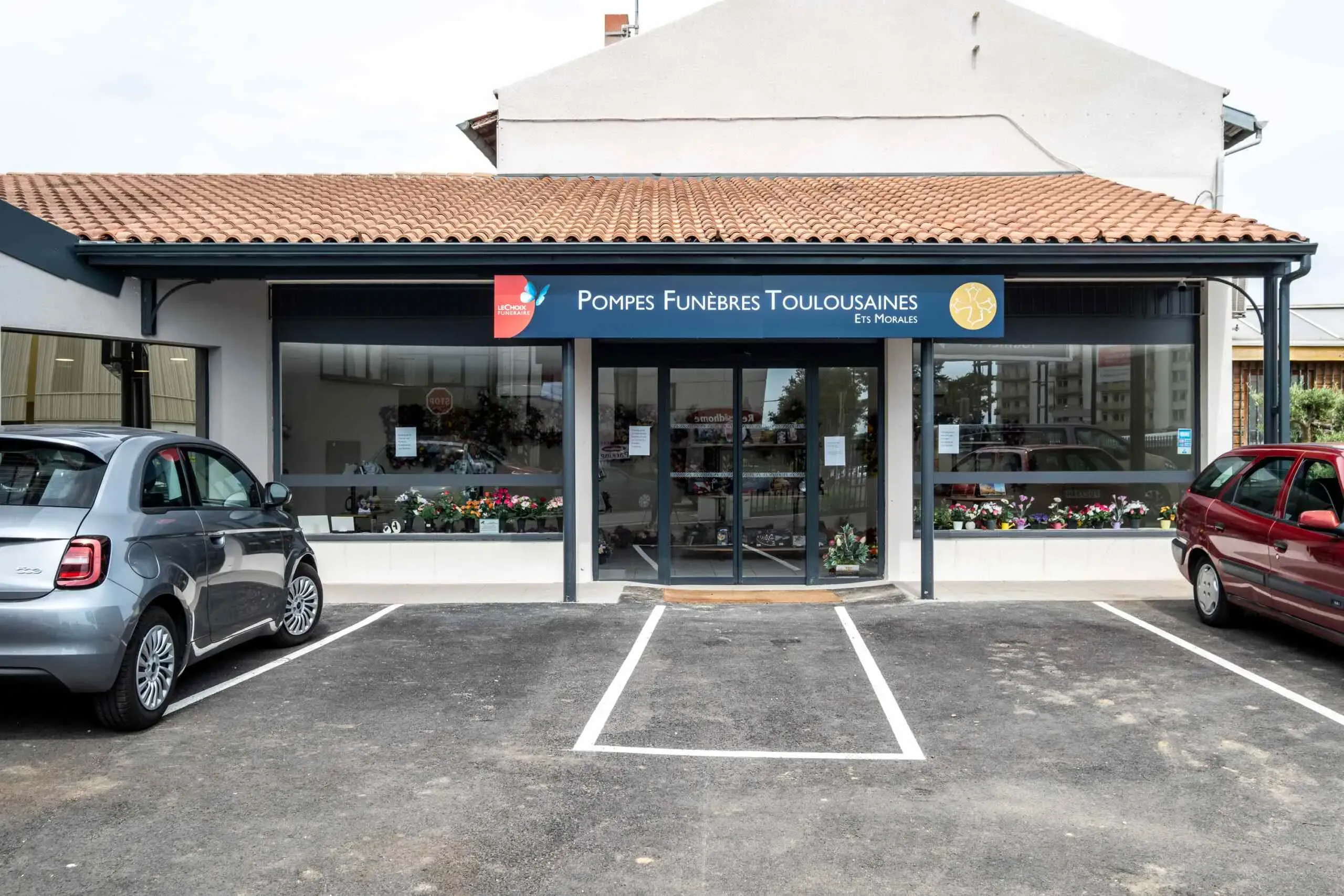 Façade extérieure de l’agence Pompes Funèbres Toulousaines avec parking réservé.